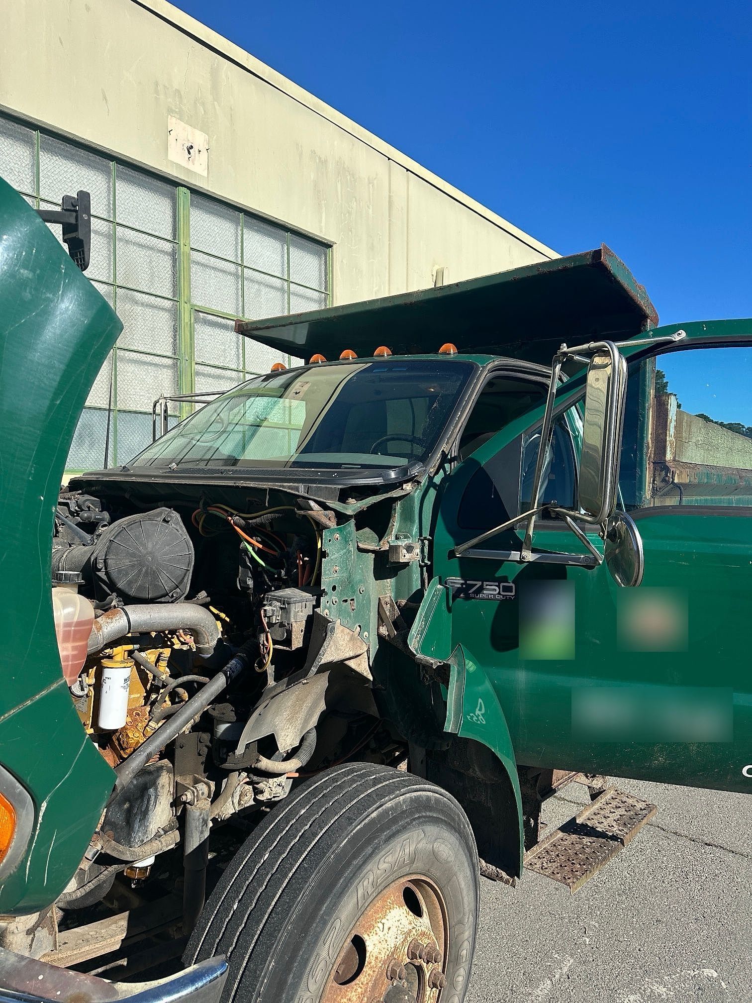 City fleet dump truck with the hood open during a Super Auto Glass windshield job