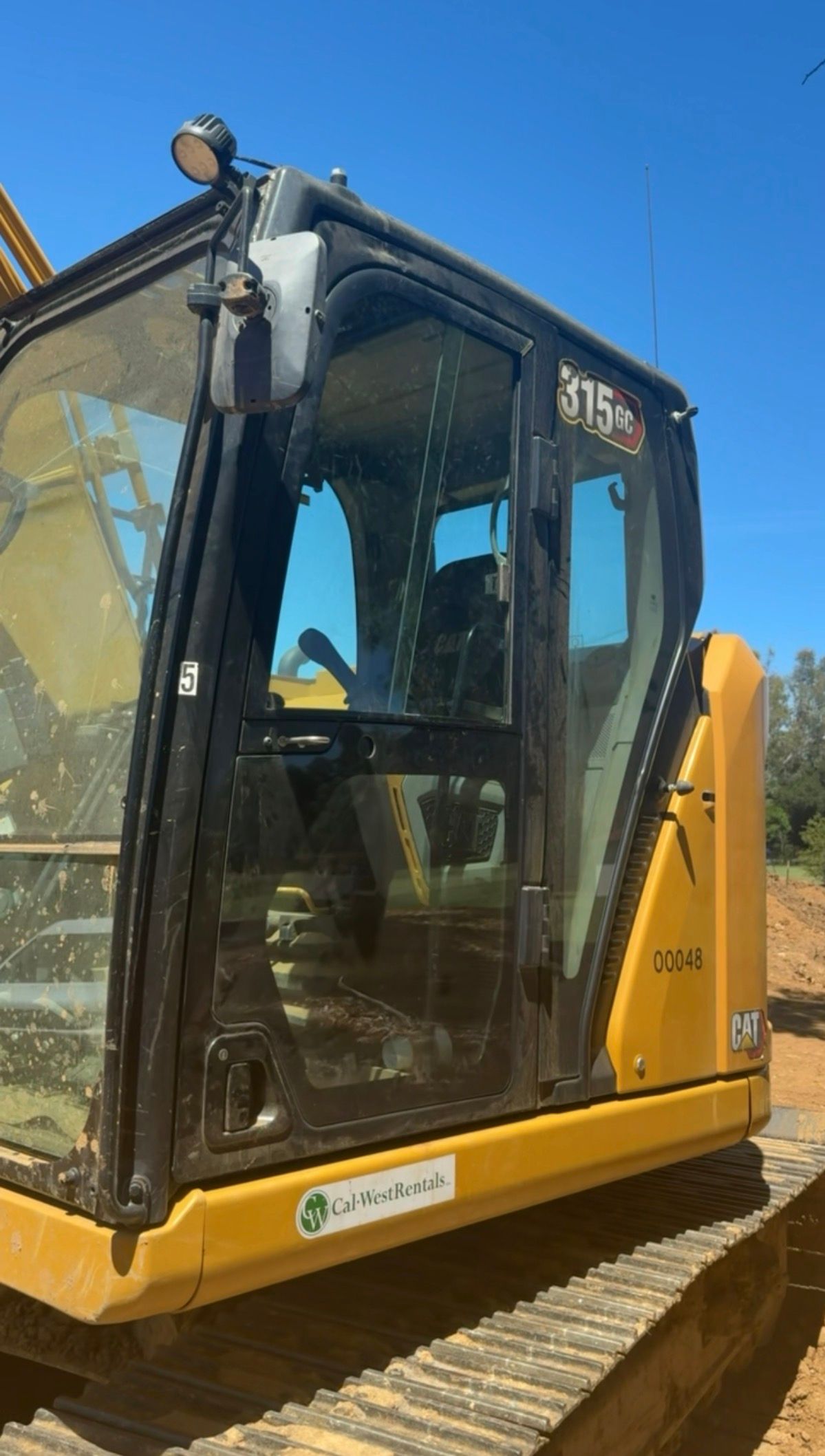 Excavator cab with its door and side glass on a job site